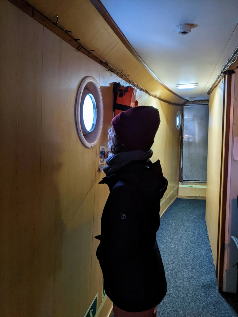 Girls looks our porthole on ferry in the Faroe Islands